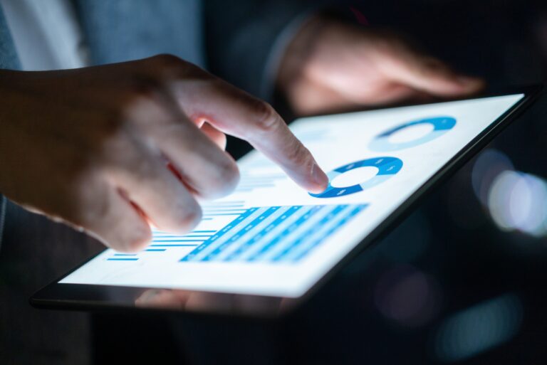 Man Holding Tablet Graphs Tables